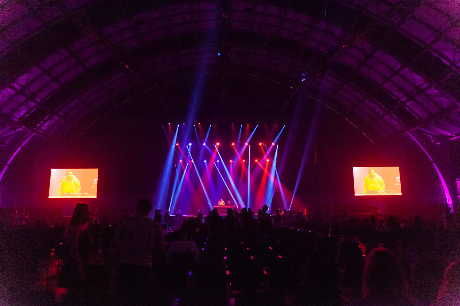 Large gig with red and blue spotlights lighting the stage