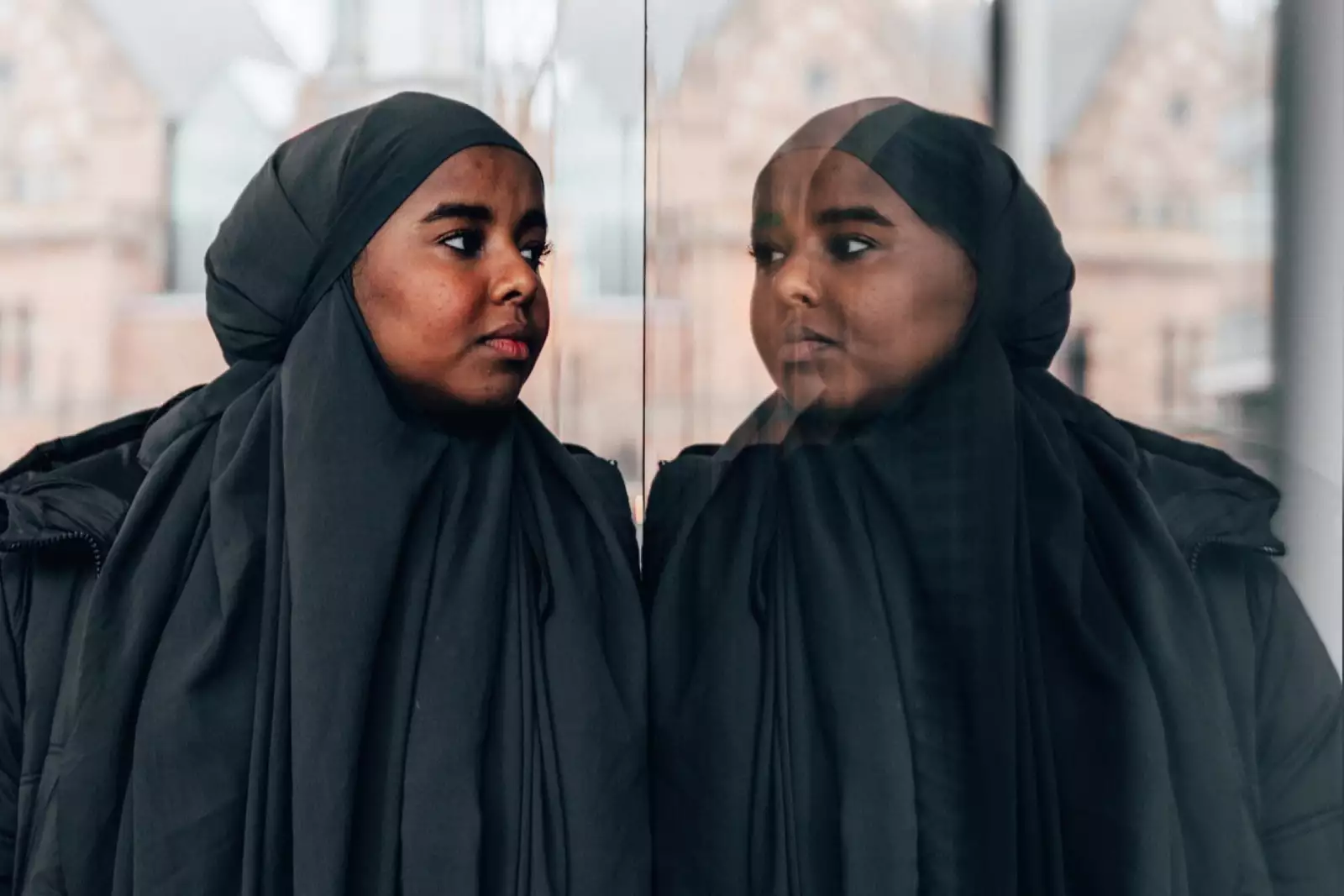 Ebyan looks at her reflection in a shop window.