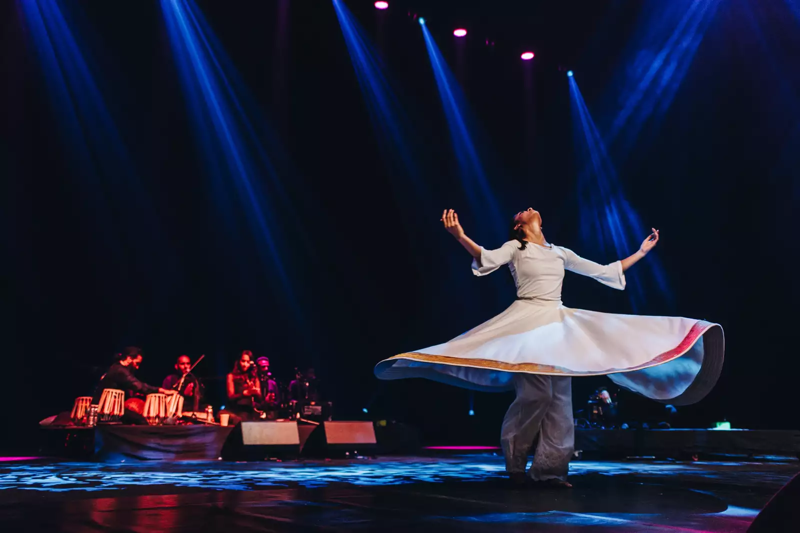 A lady in a white dress dancing on stage