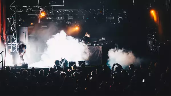 Artist Aisha Devi on stage with dj decks with plums of smoke