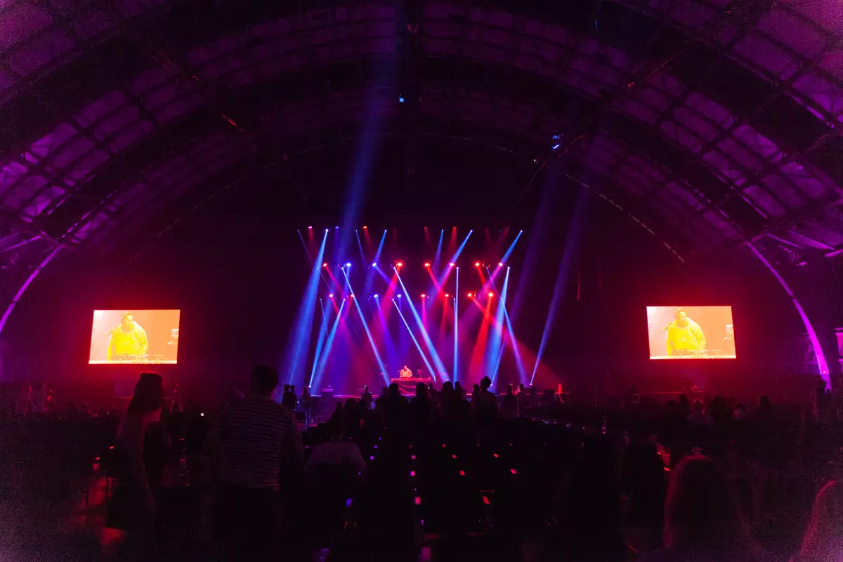 Large gig with red and blue spotlights lighting the stage