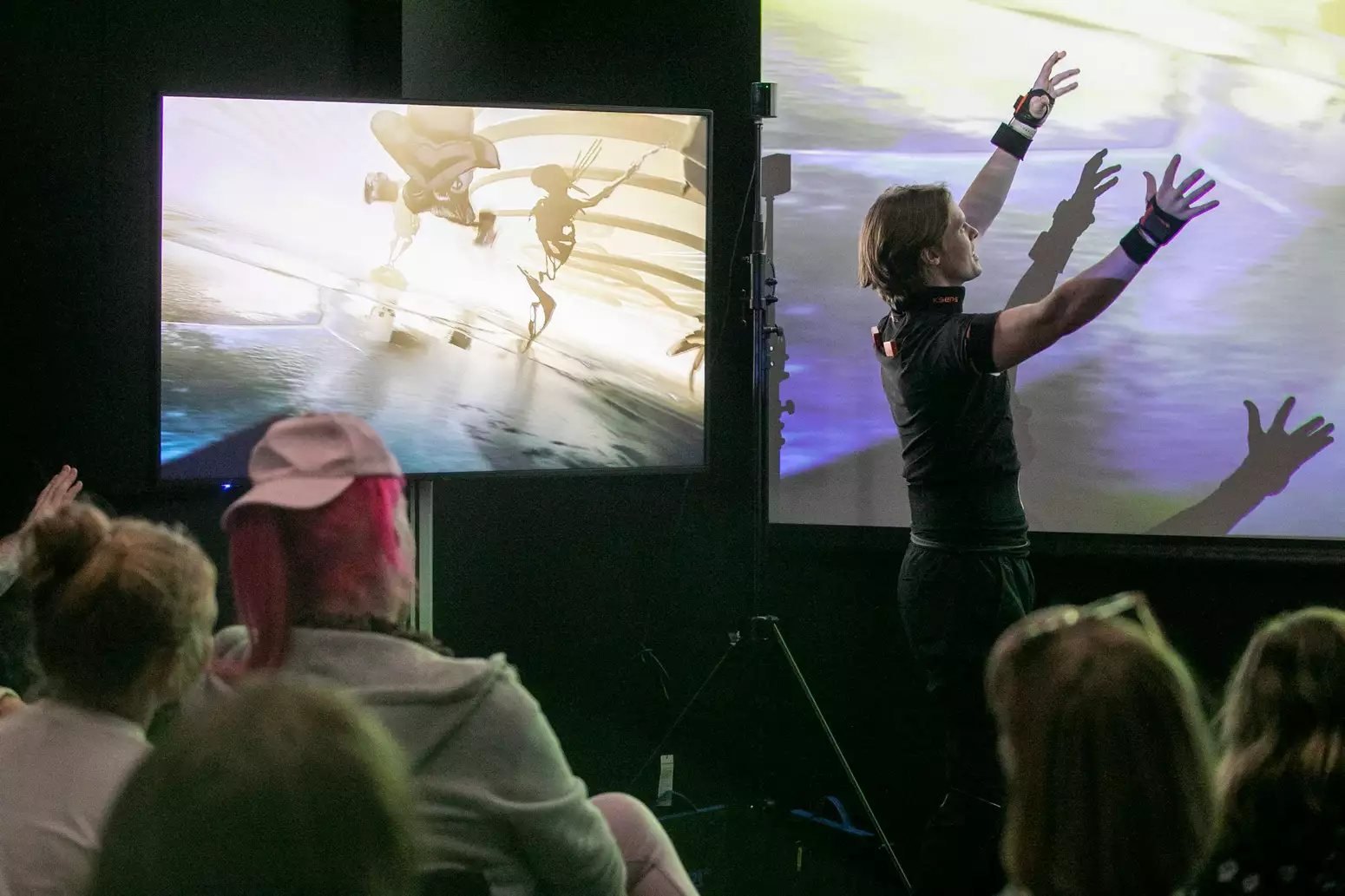 A man presenting in front of a digital screen
